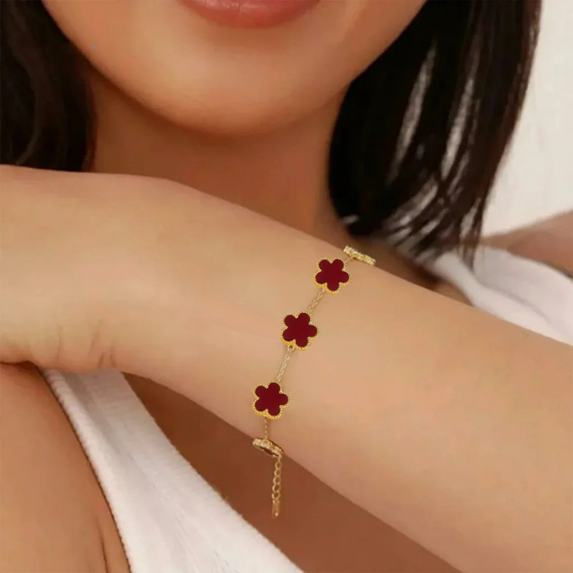 Gold four-leaf clover bracelet stacked on wrist, hypoallergenic lucky charm jewelry for women's gifting