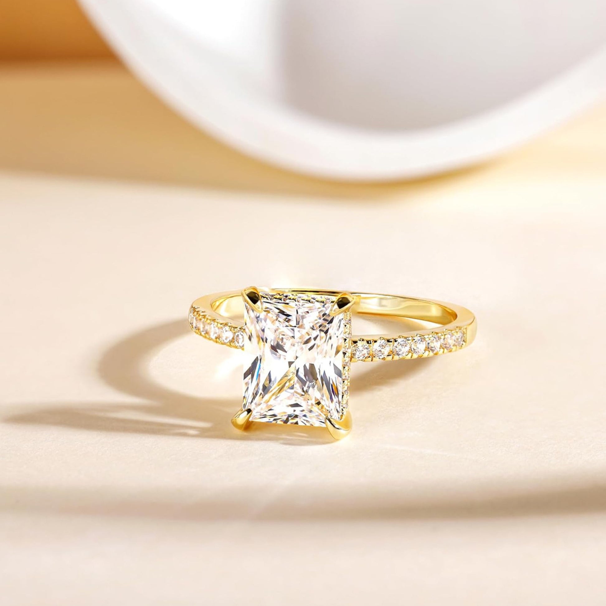 Side view of gold rectangular white diamond four-prong ring, sparkling band design, trendy fashion jewelry for women